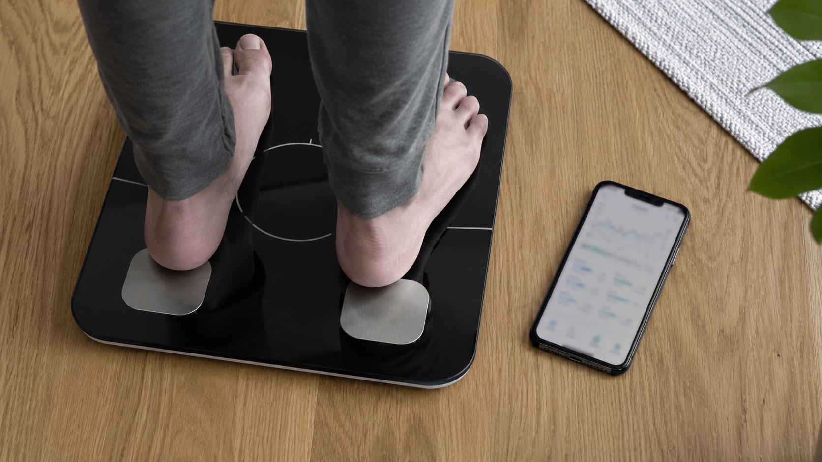 体組成計に乗り、スマホに記録される様子