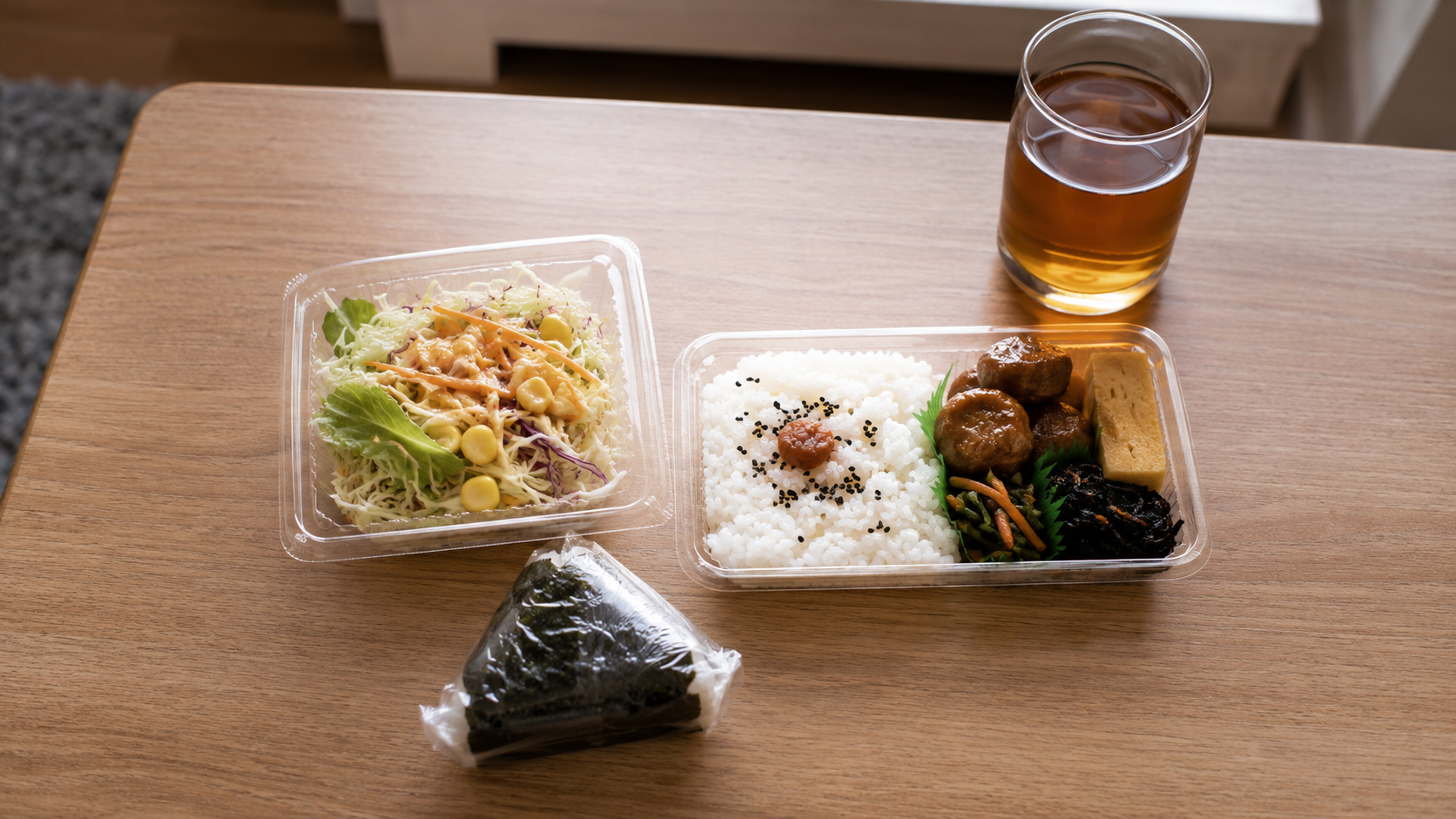 コンビニのおにぎりにパックのサラダやゆで卵を1つ添えた食卓