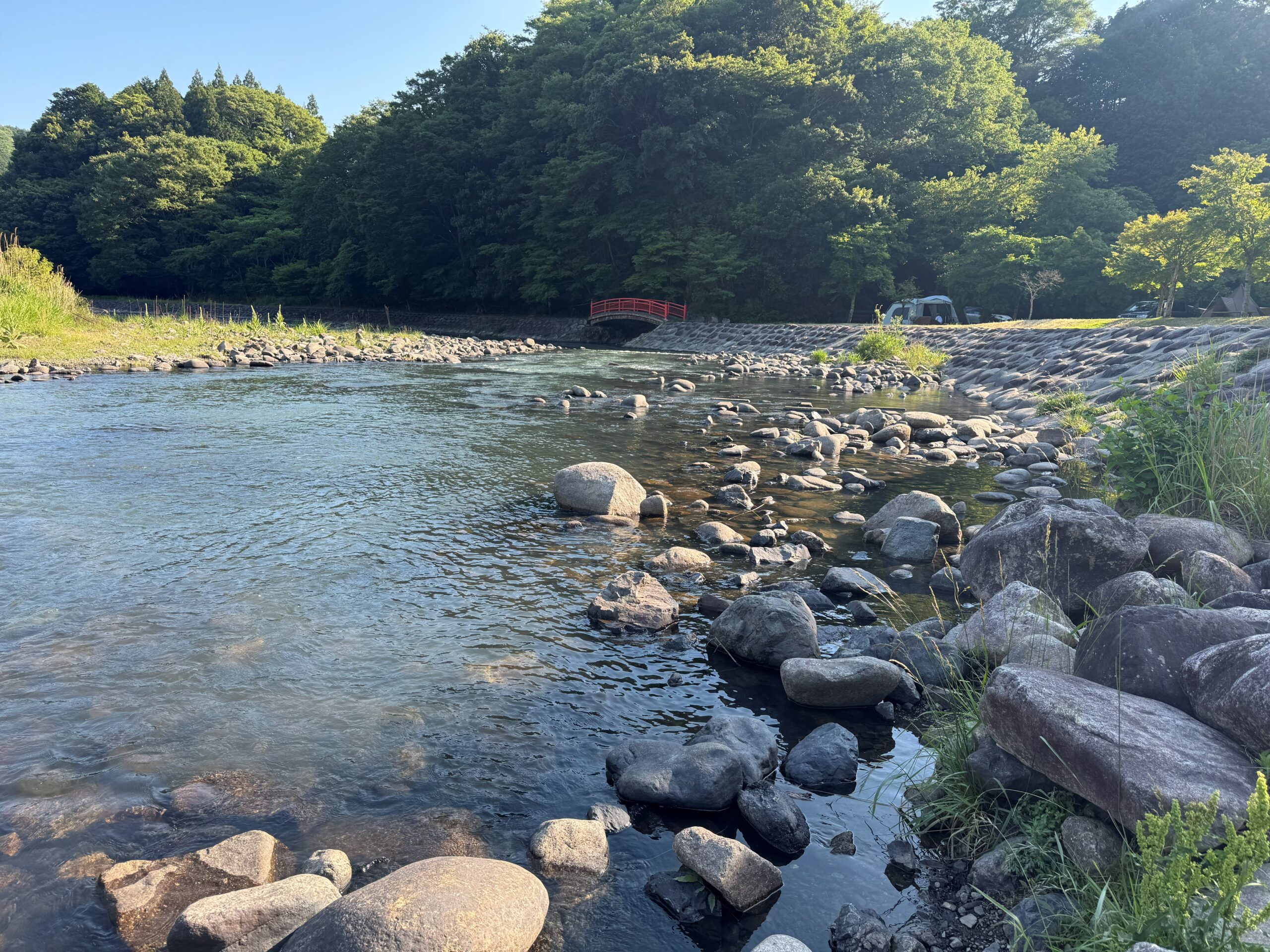 澄んだ川と奥に見える赤い橋