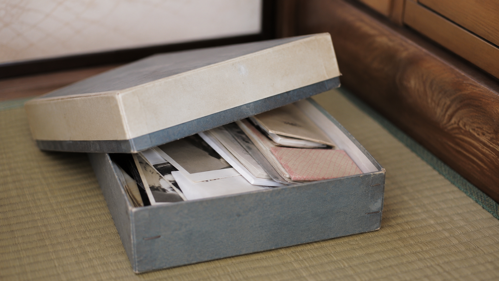 押し入れから出した思い出の品の箱、開けたまま手が止まる