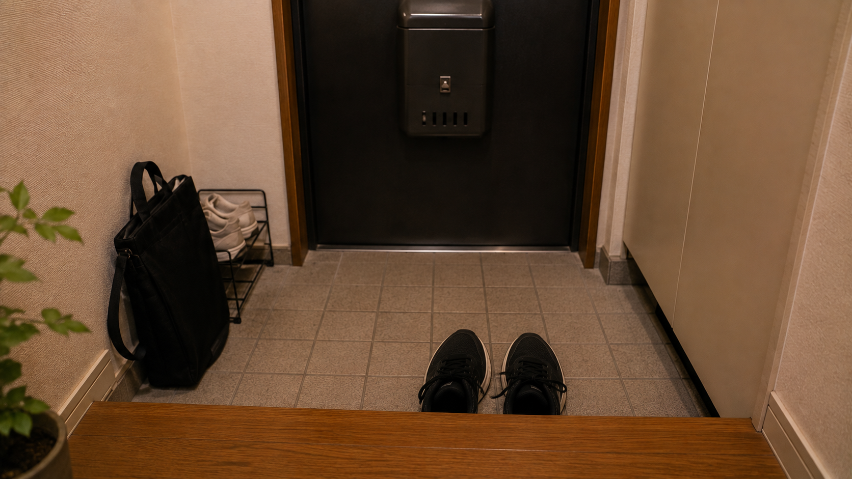 玄関で靴を履く足元とバッグ